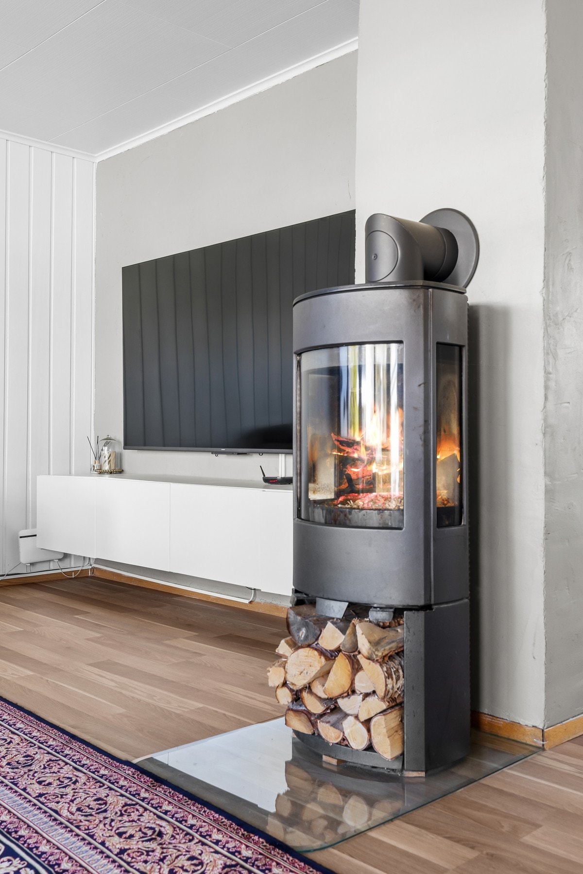 Peis for vedfyring som gir en deilig lun atmosfære i rommet. Galleribilde