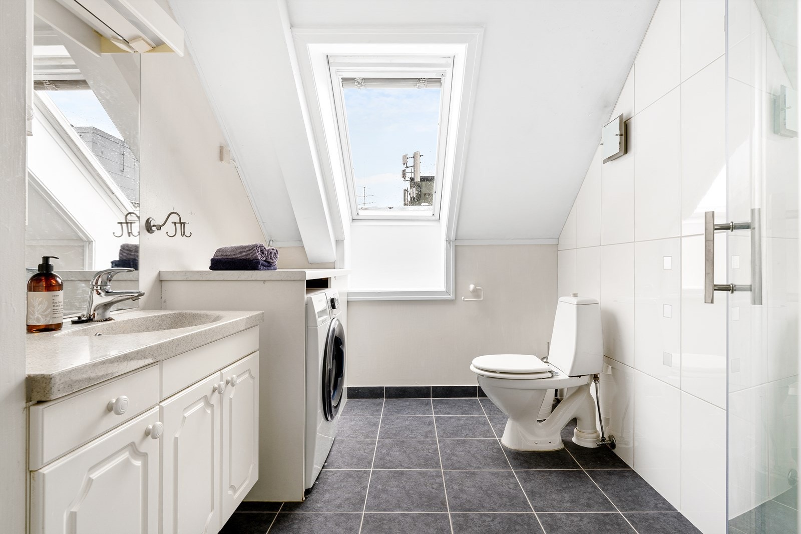 Badet er på 5.2 kvm med flislagt gulv. Praktisk løsning for vaskemaskin. Galleribilde