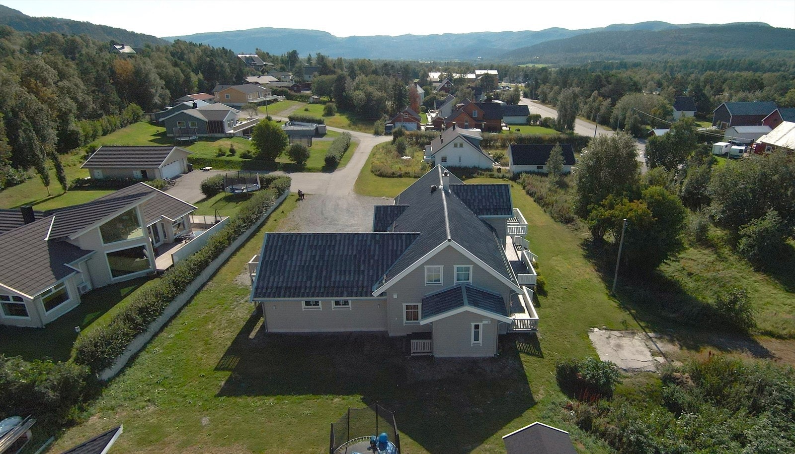Stor tomt på 2465 kvm opparbeidet med asfalt og grus i innkjøringen, plen og beplanting, boligen har stor terrasse mot sørvest. Galleribilde