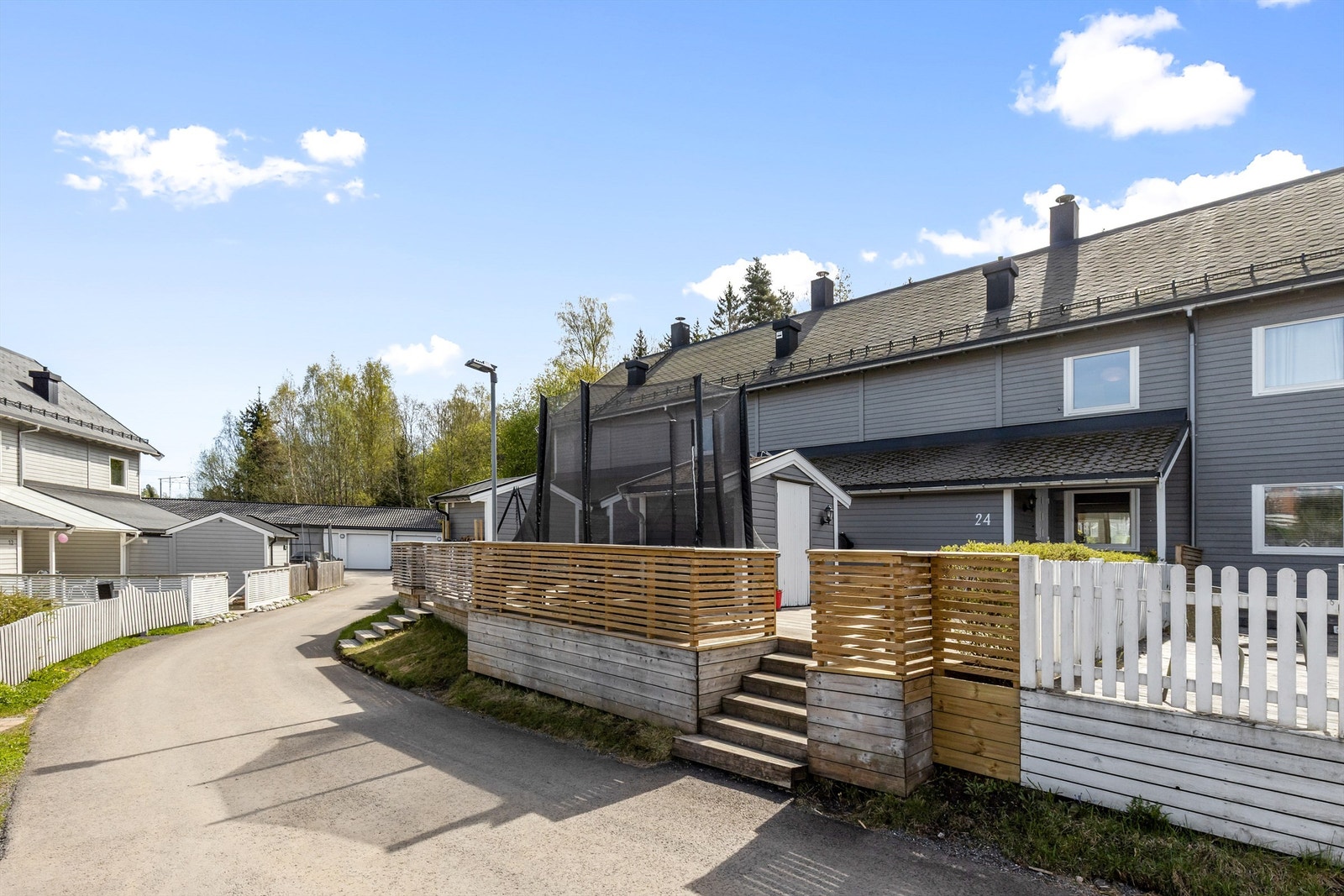 Inngangspartiet er pent opparbeidet med inngjerding og terrasseplatting. Galleribilde
