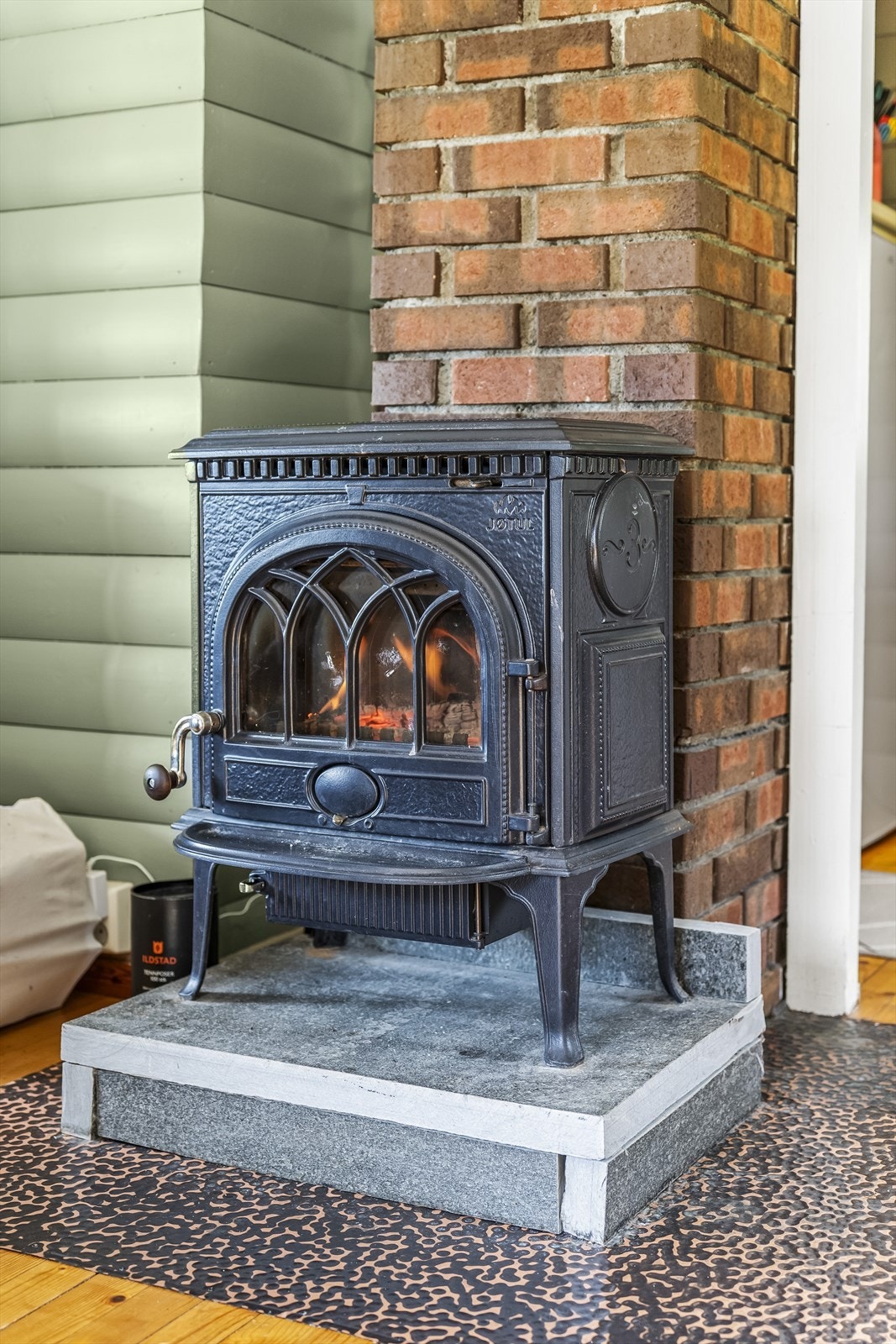 Vedfyrt ovn plassert sentralt i stue Galleribilde