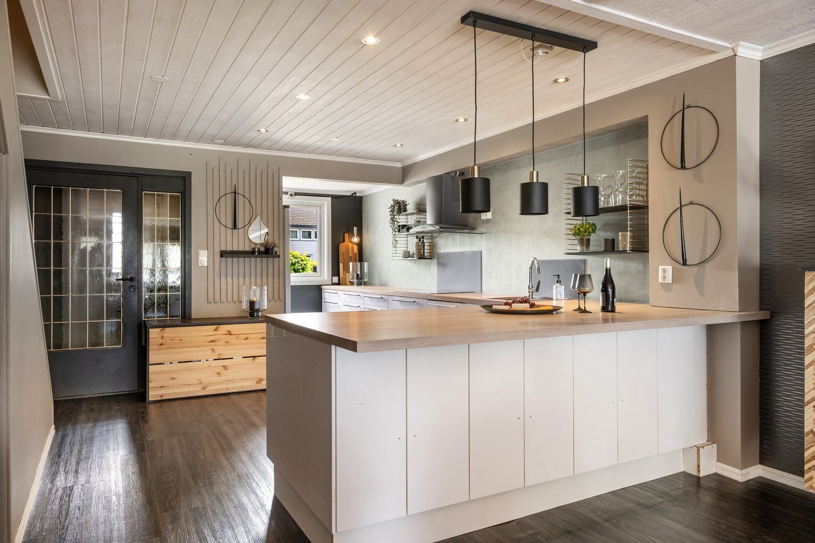 Romslig kjøkken i hvit utførelse uten overskap som skaper en veldig god romfølelse. Galleribilde