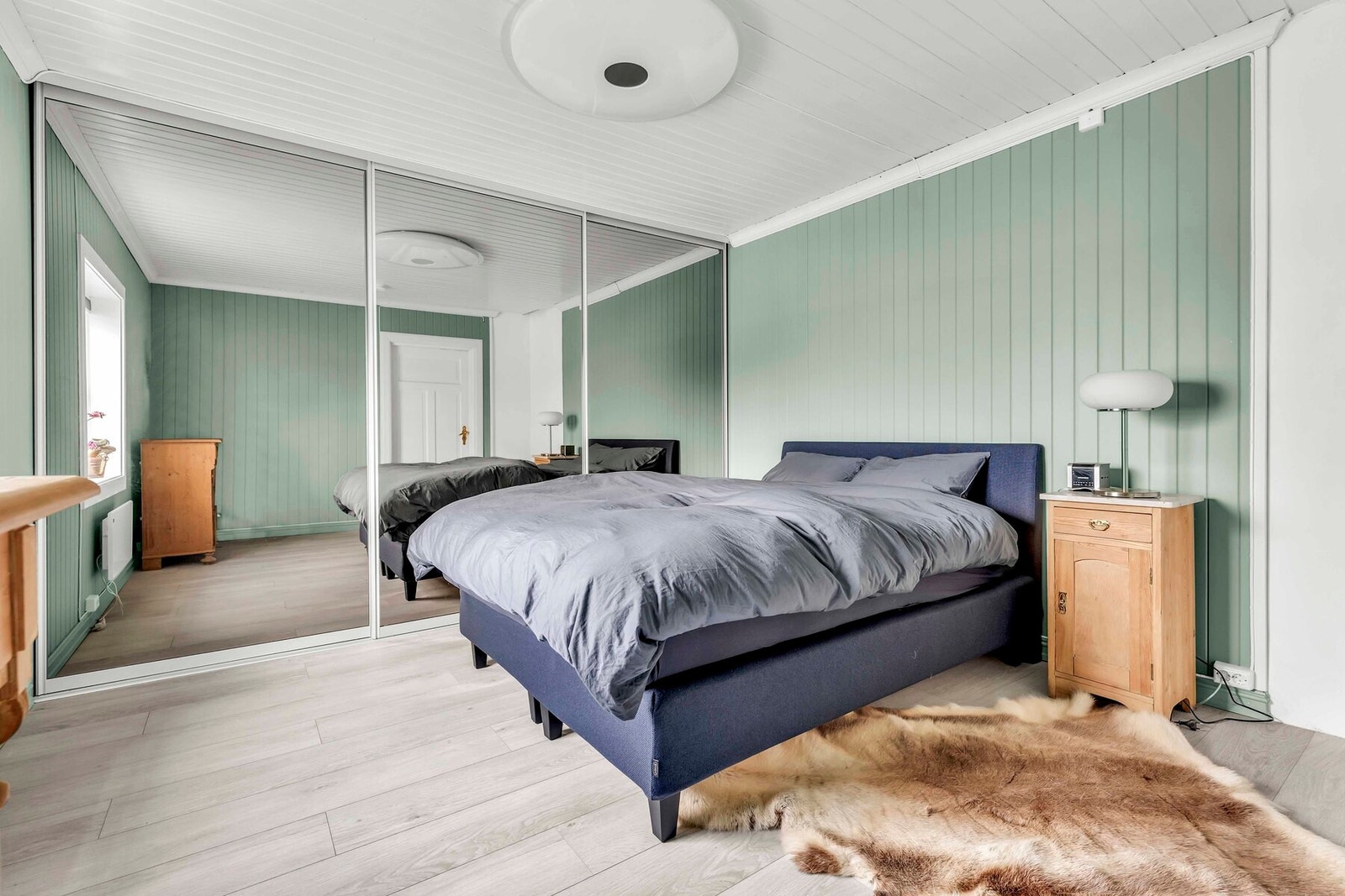 Stort og innbydende hovedsoverom med skyvedørsgarderobe Galleribilde