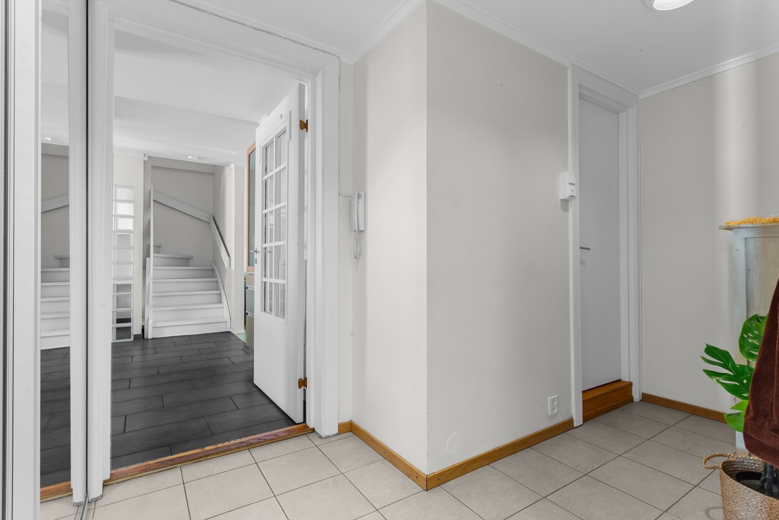 Romslig hjørneformet entré med dør til etasjens baderom. Det var tidligere en dør mellom gangen og spisestuen som kan gjenåpnes. Galleribilde