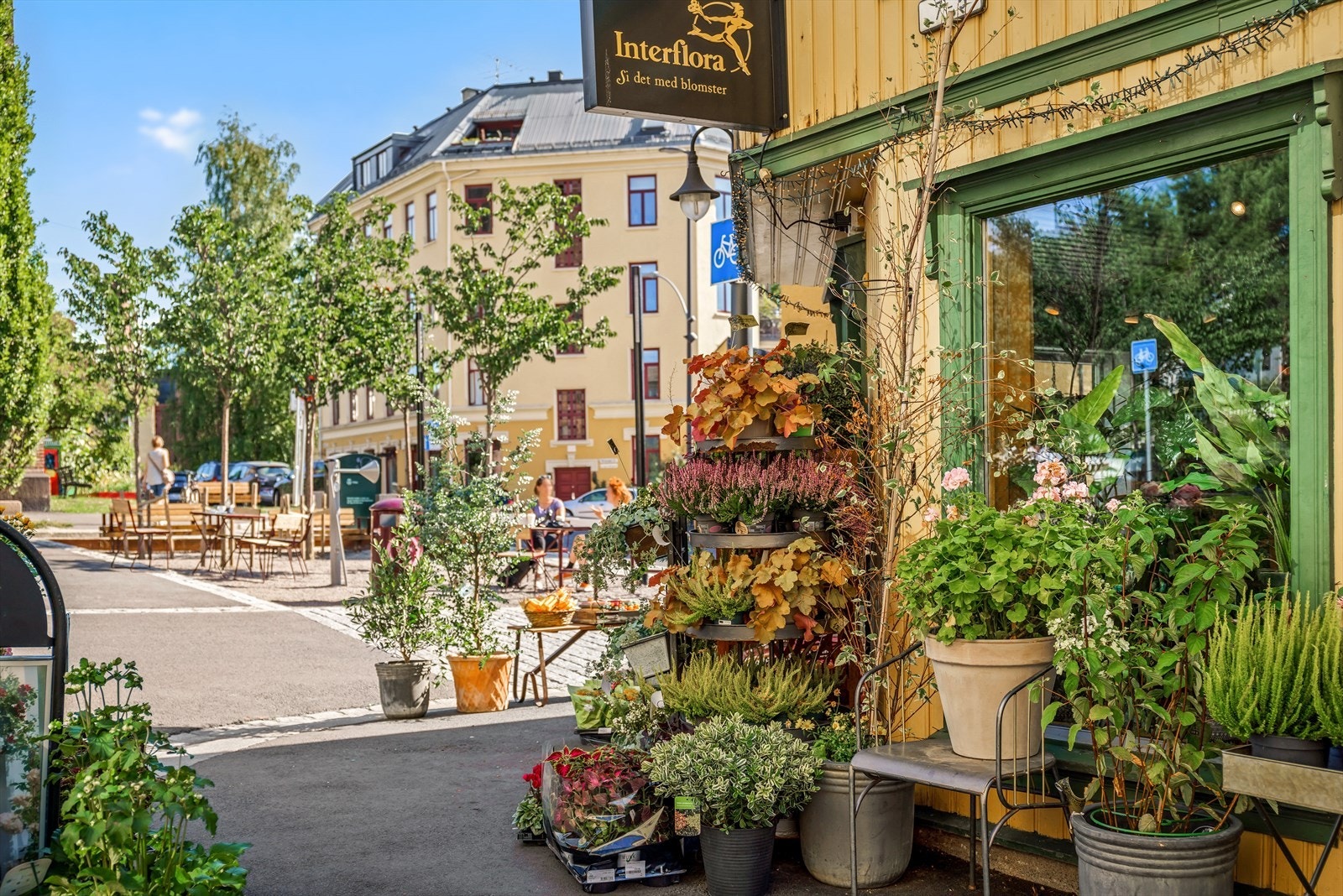 Blomsterbutikken og Torbjørn Egners plass med uteservering foran kirken. Galleribilde