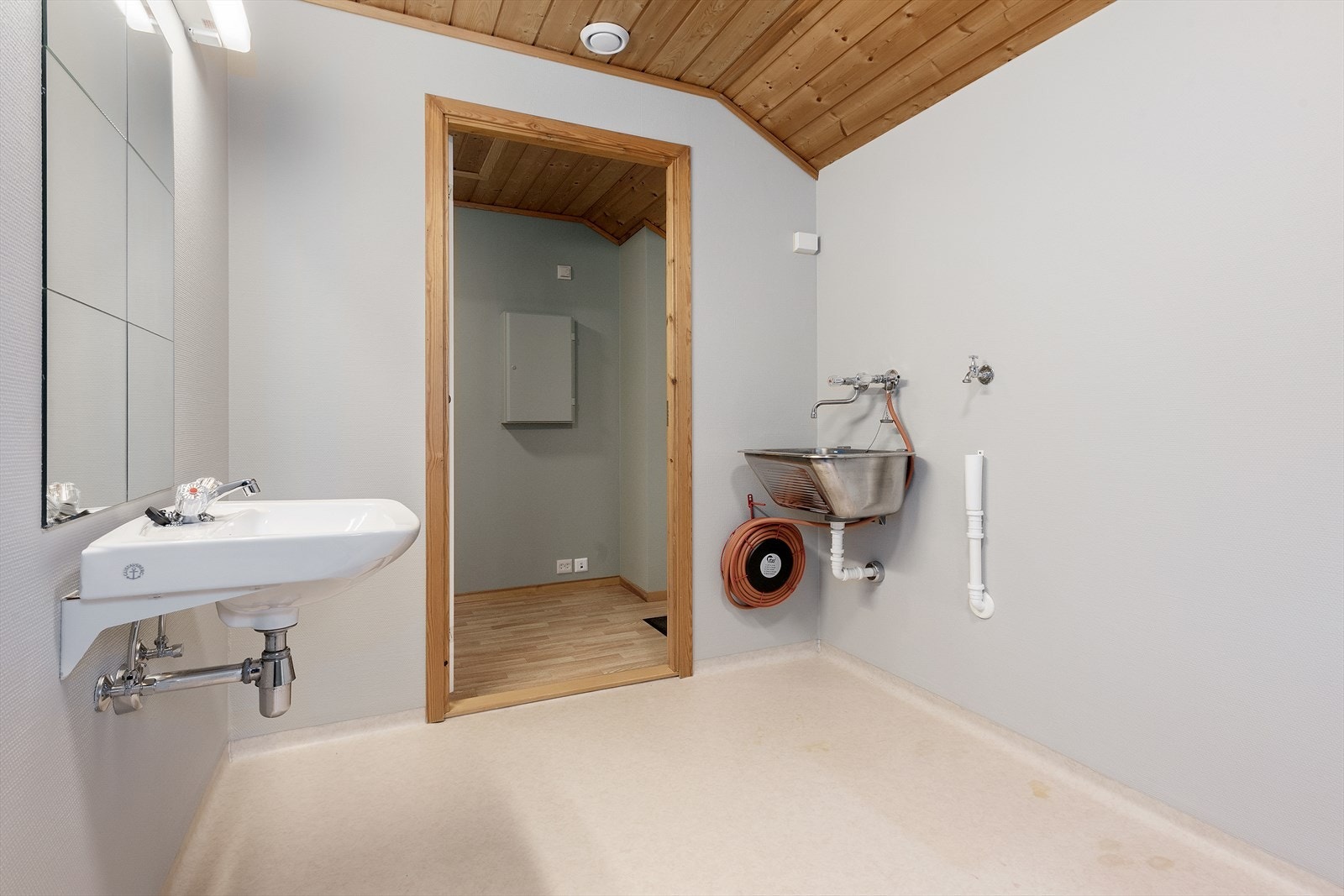 Badet er utstyrt med vaskeservant, stål vaskekum og tilkobling for vaskemaskin og tørketrommel. Galleribilde