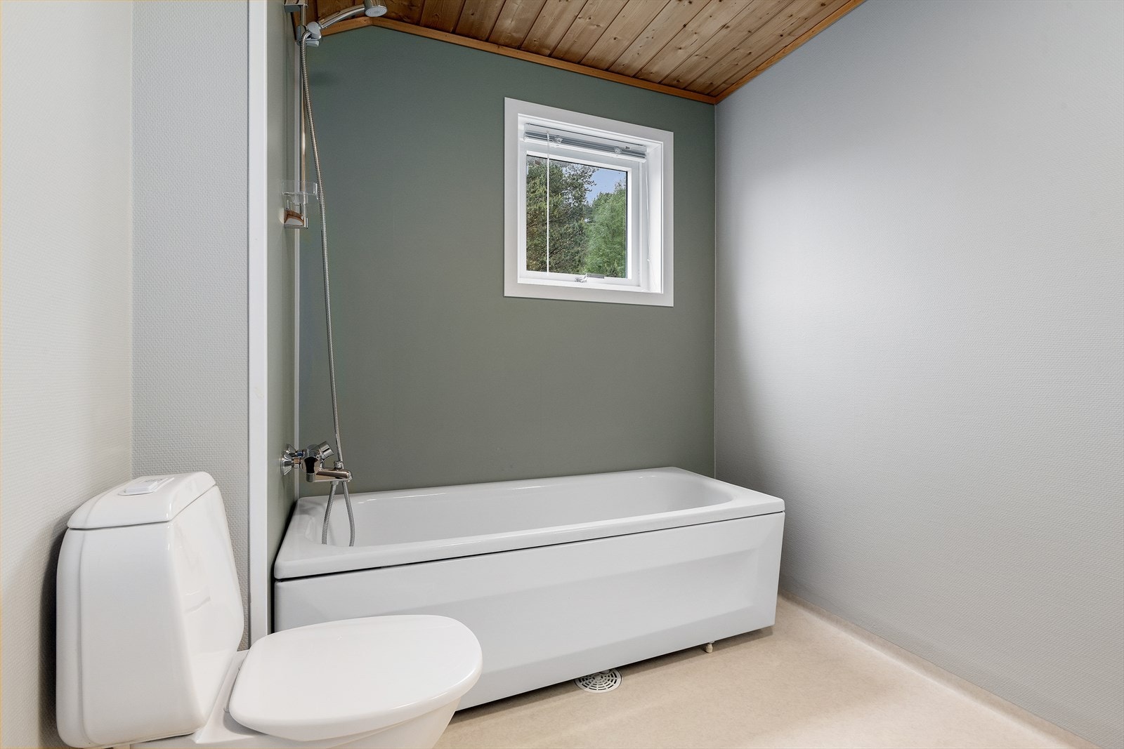 Det er badekar og wc i badet. Galleribilde