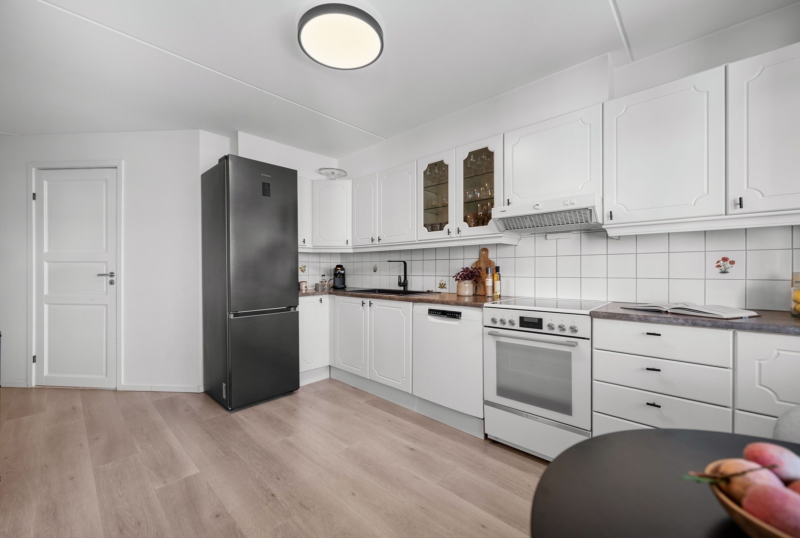 Kjøkkenet har frittstående hvitevarer som kjøleskap, stekeovn og oppvaskmaskin. Galleribilde