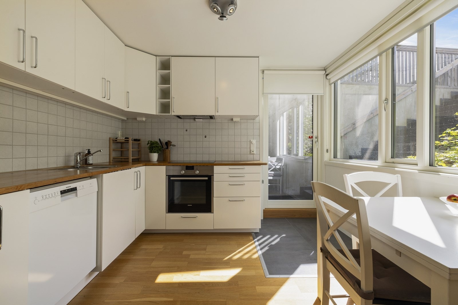 Kjøkkenet har slette fronter og heltre eik benkeplate. Integrert komfyr, oppvaskmaskin og kjøl/frys Galleribilde