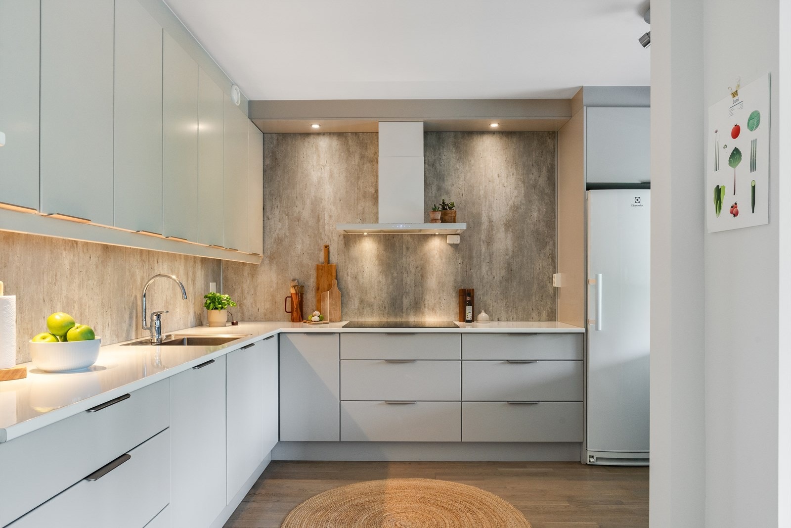 Kjøkkenet har gjennomgående detaljer i hvitt og stål og spotter over kjøkkenbenk, noe som gjør at rommet får et rent og delikat uttrykk. Galleribilde