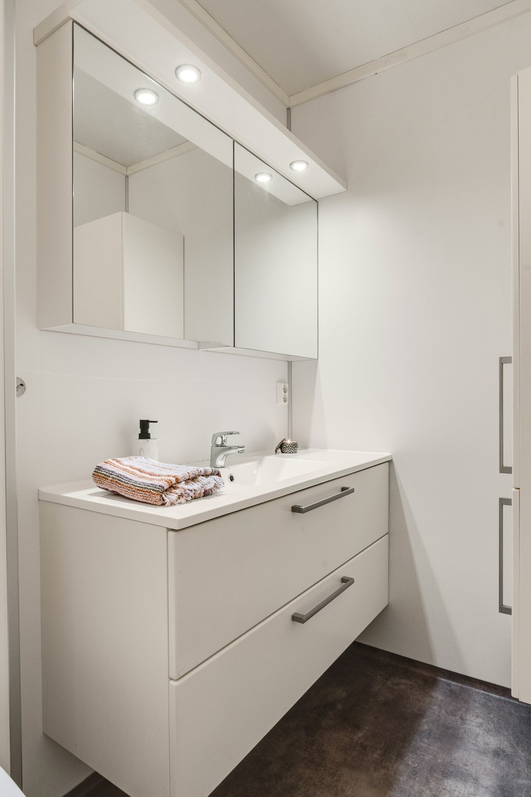 Baderom med pen seksjon i høyglans med servant, samt praktise overskap med speil og spotter. Galleribilde