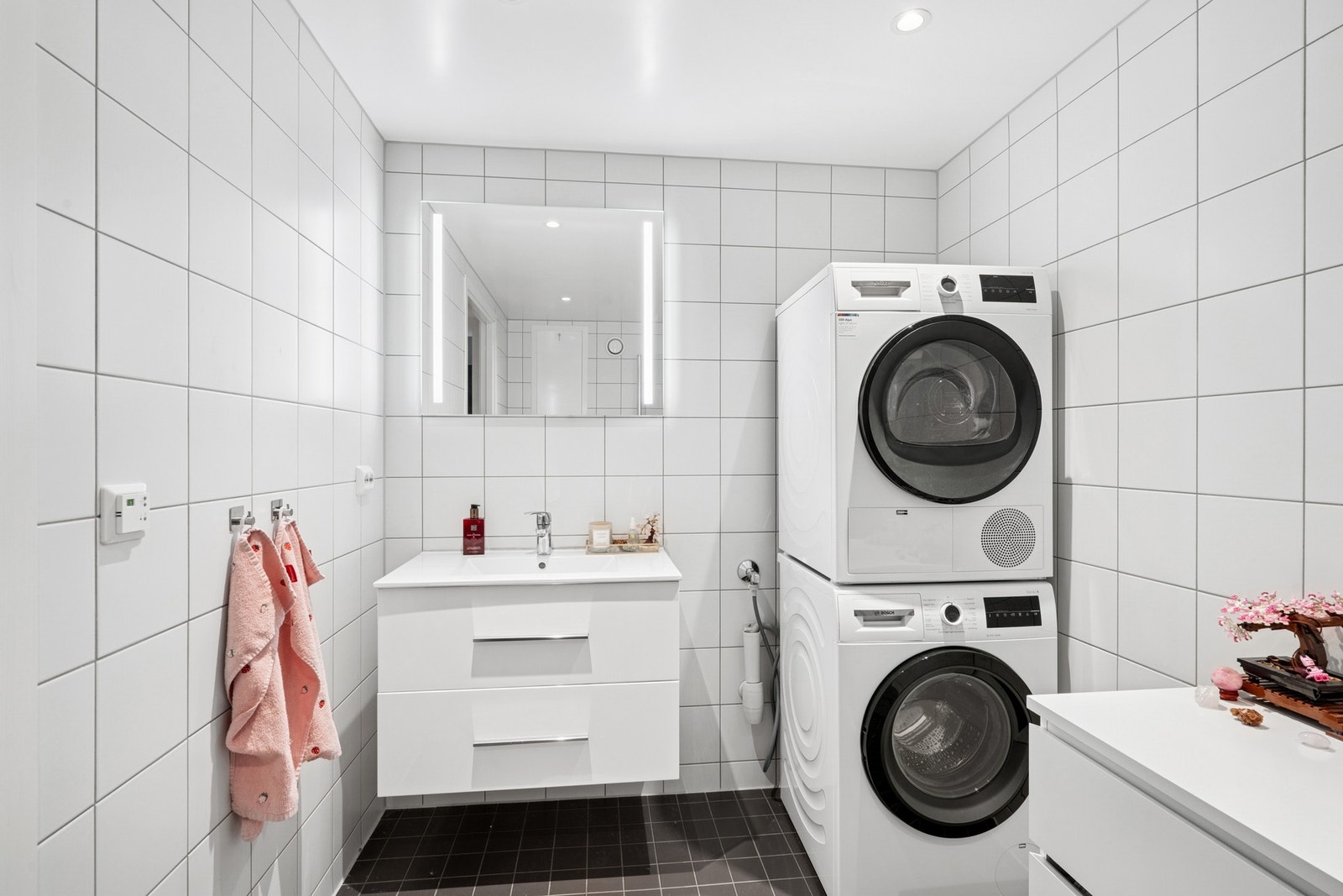 Lyst og pent bad med varme i gulvet og opplegg for vaskemaskin og tørketrommel. Galleribilde