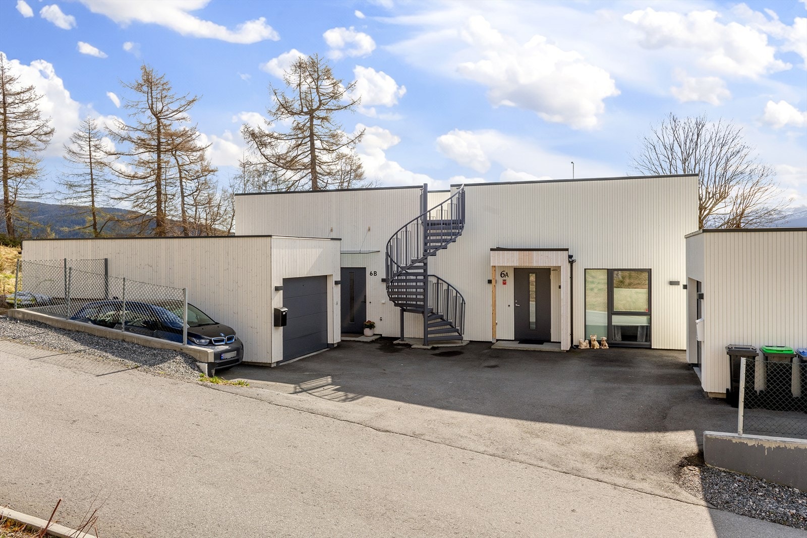 Asfaltert innkjørsel. Garasje med el-bil lader. Galleribilde