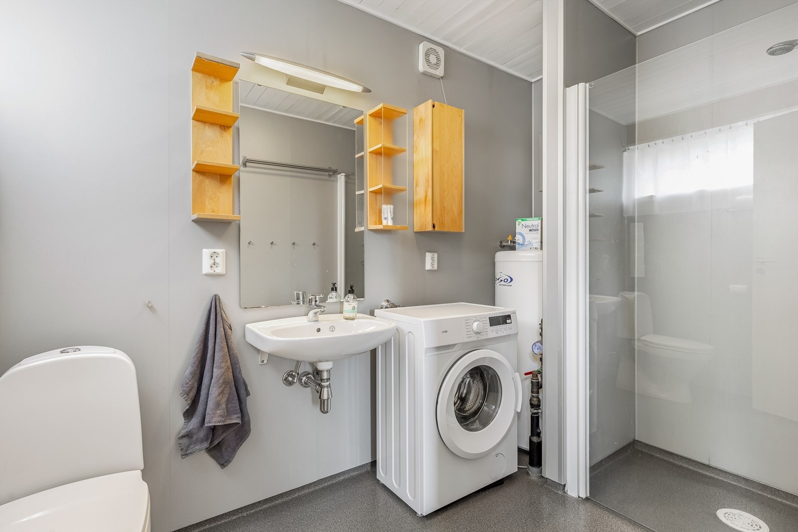 Bad med toalett, vask, dusj og opplegg for vaskemaskin Galleribilde