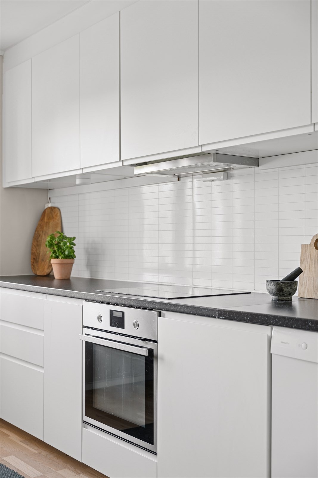 Kjøkkenet er innredet med glatte, folierte fronter, laminat benkeplate og kum i rustfritt stål. Galleribilde