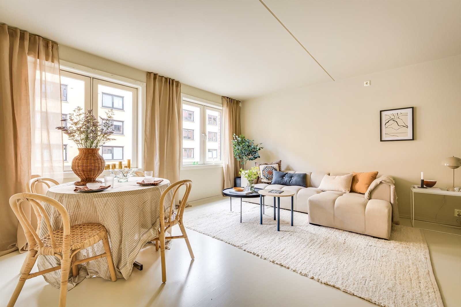 Lys og innbydende stue med nøytral fargepalett og store vinduer. Galleribilde