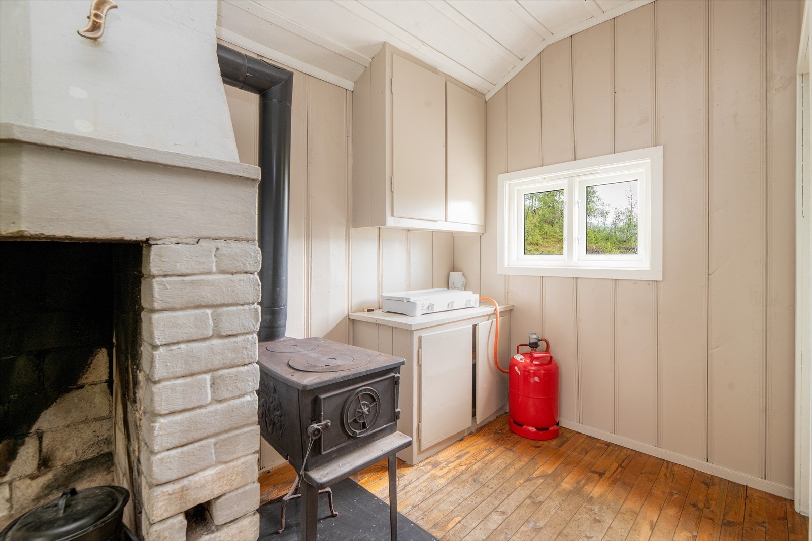 I stuen er det åpen peis og vedovn ved kjøkkenkroken. Vedovn ved kjøkkenkroken i dag er plombert for å slippe feieavgift. Galleribilde