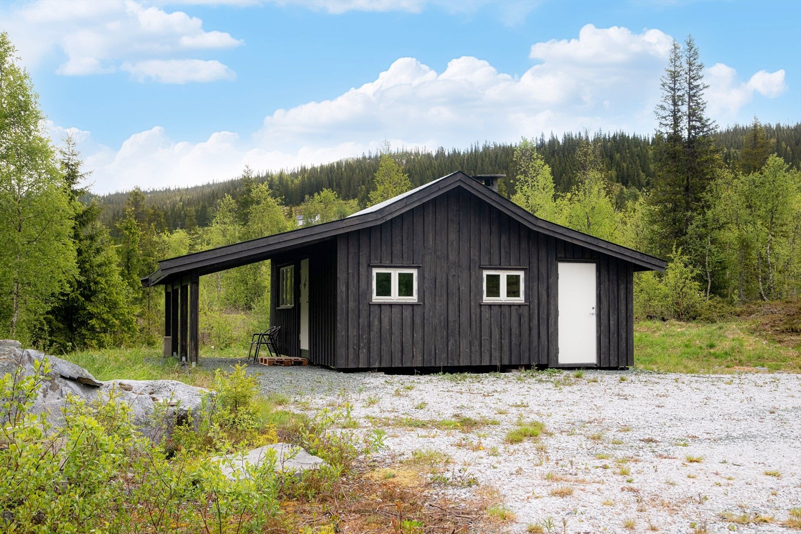 Nydelig og solrik naturtomt med naturlig vegetasjon samt romslig gruset gårdsplass med flere biloppstillingsplasser. Galleribilde