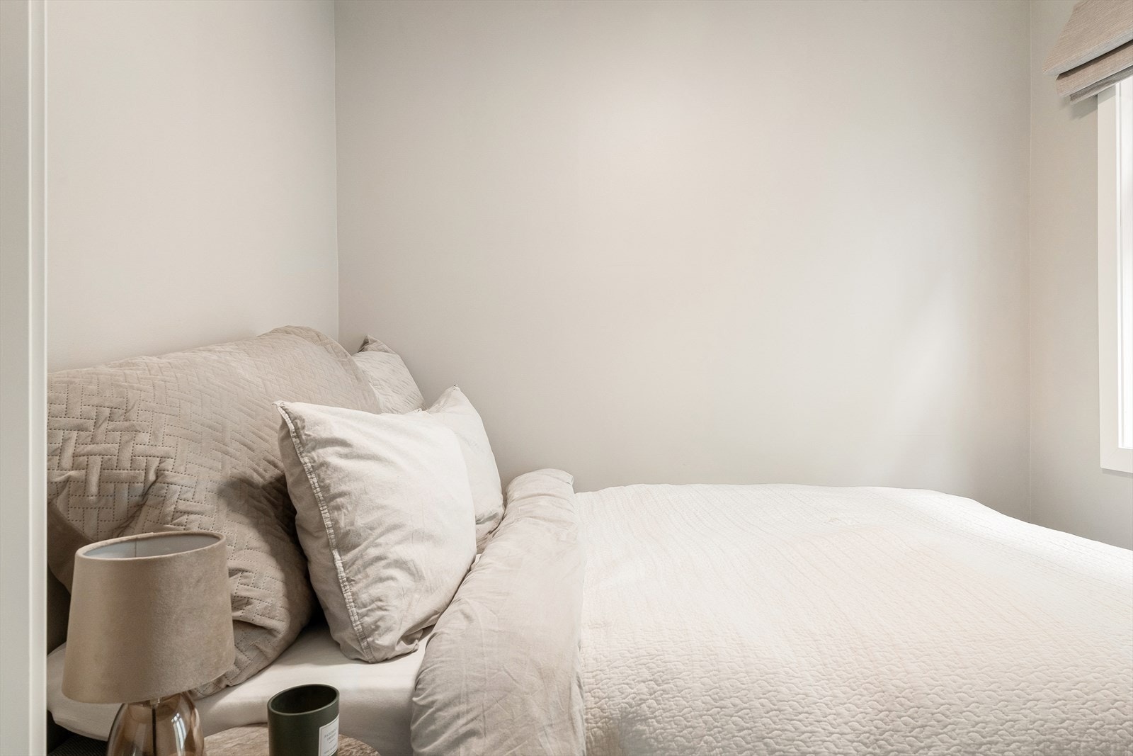 Lyst og trivelig soverom med plass til dobbeltseng og noe annen oppbevaring Galleribilde