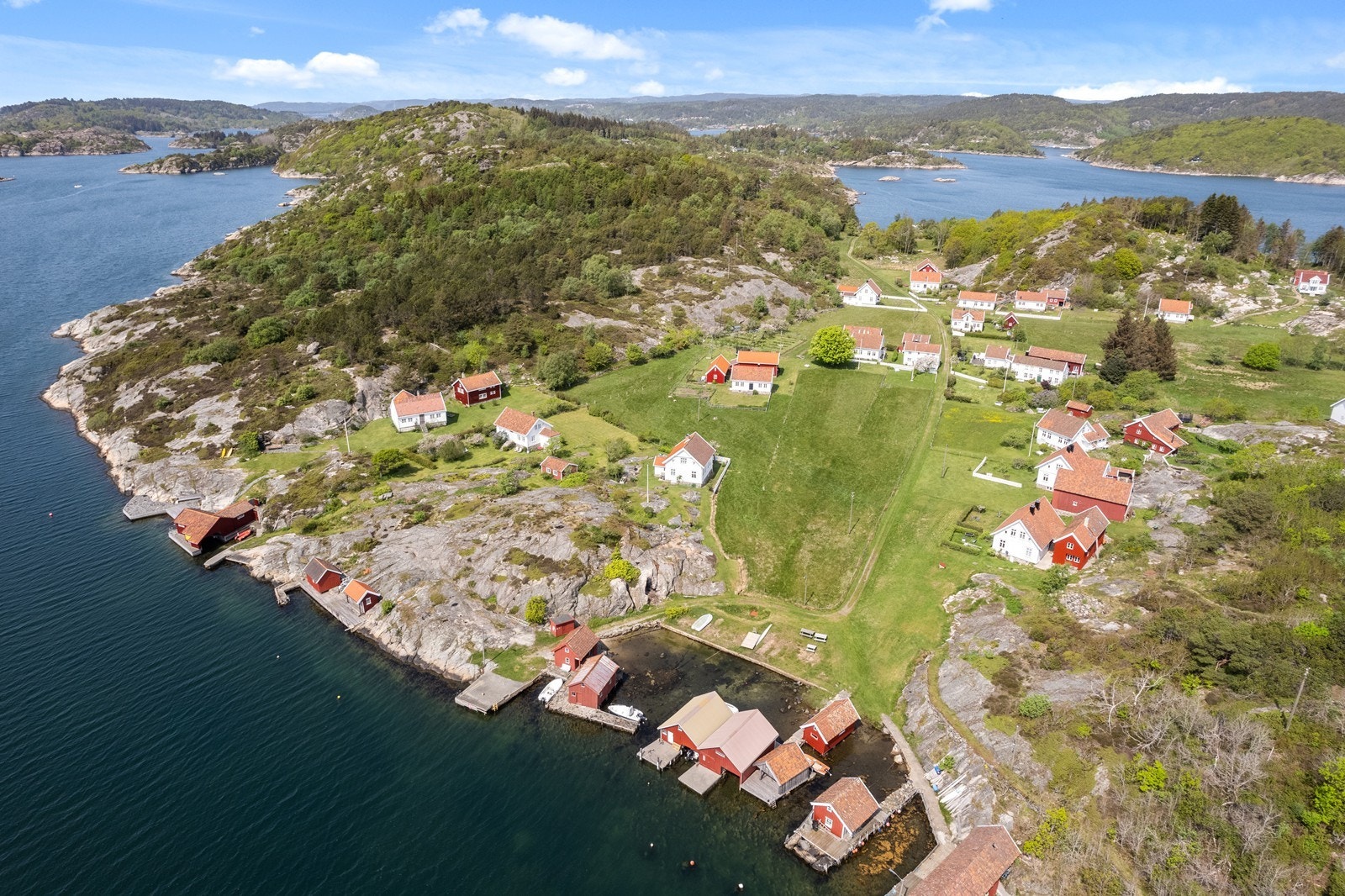 Sørstranda i front med den gamle bebyggelsen midt på bildet. Landøy 128 ligger på en topp rett utenfor høyre bildekant. Galleribilde