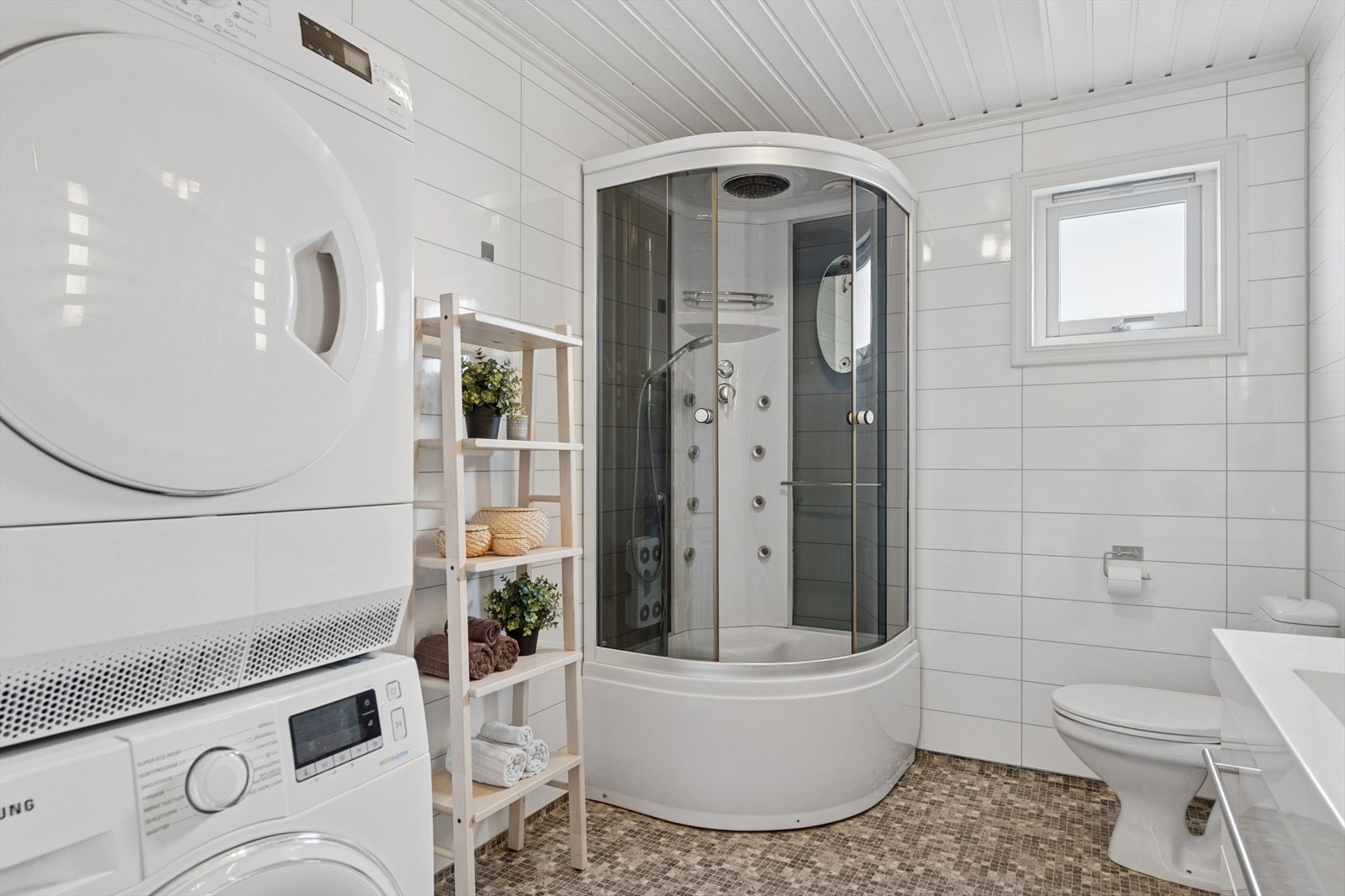 Badet har innredning med nedfelt servant, toalett, dusjkabinett og opplegg for vaskemaskin. Galleribilde