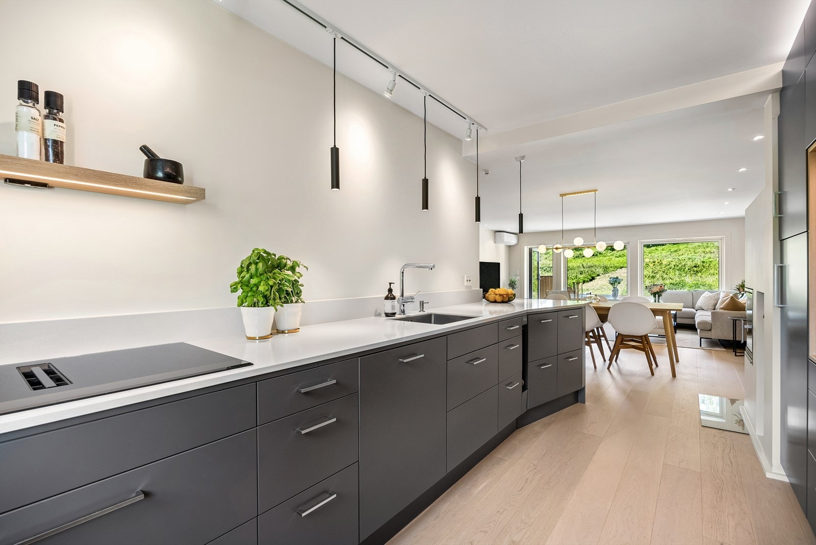 Induksjonstopp, stekeovn, oppvaskmaskin, mikrobølgeovn og kjøl/frys er integrert i innredningen Galleribilde