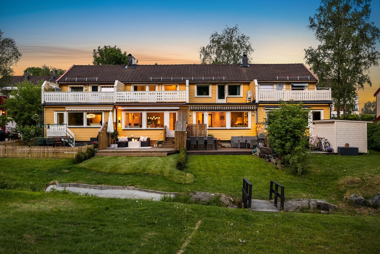 Rekkehuset går over tre plan og har en vestvendt terrasse med direkte adkomst til en pen, opparbeidet hage Galleribilde