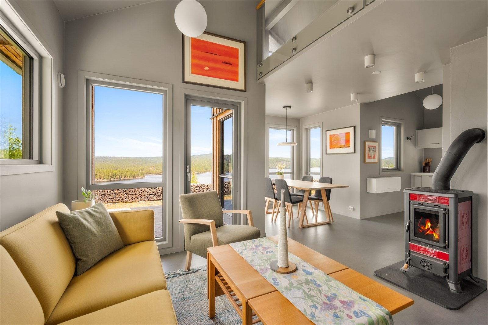 Vedfyring i stuen. Stuen er åpen mot kjøkken og har en fantastisk takhøyde som gjør den luftig. Galleribilde