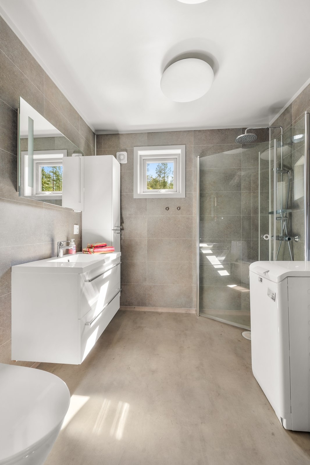 Bad innredet med dusjhjørne, servant i møblement. Galleribilde