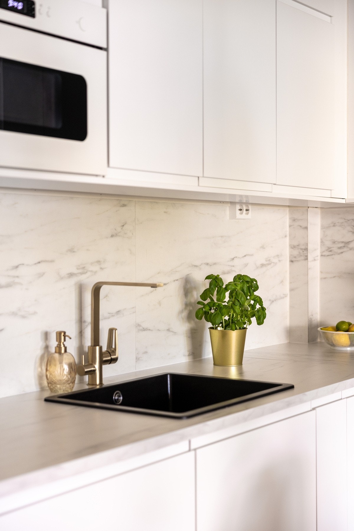 Kjøkkenplater mellom benkeplate og overskap samt stikkontakter og belysning over benkeplate. Galleribilde