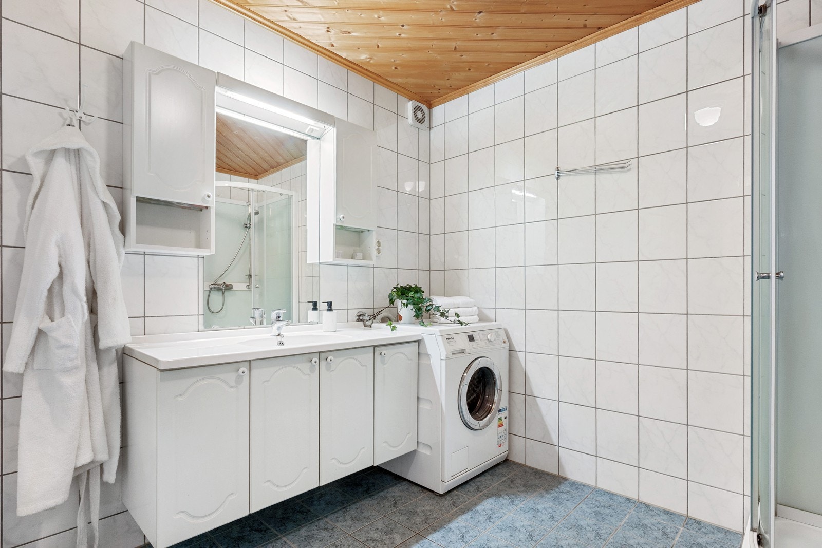Det romslige badet har flislagte overflater og gulvvarme. En stor innredning gir godt med oppbevaring for håndklær, toalettartikler o.l. Galleribilde