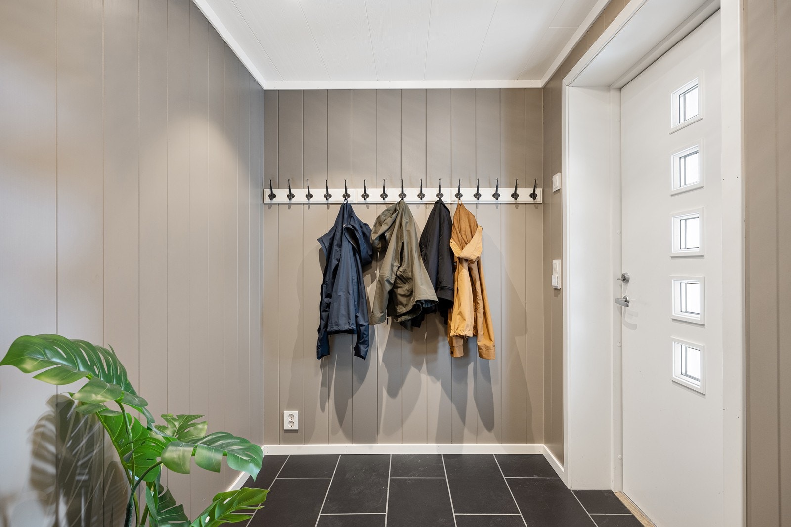I entreen er det pene mørke fliser på gulv og en delikat beige tone på vegger. Galleribilde