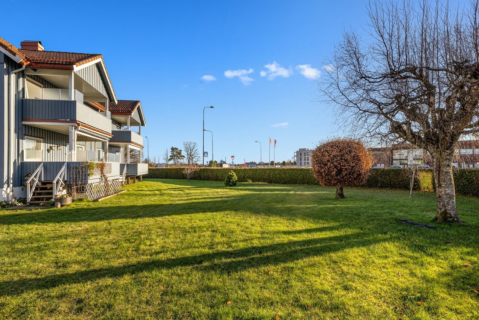 Stor felles hage med plen rundt hele huset og asfaltert gårdsplass Galleribilde