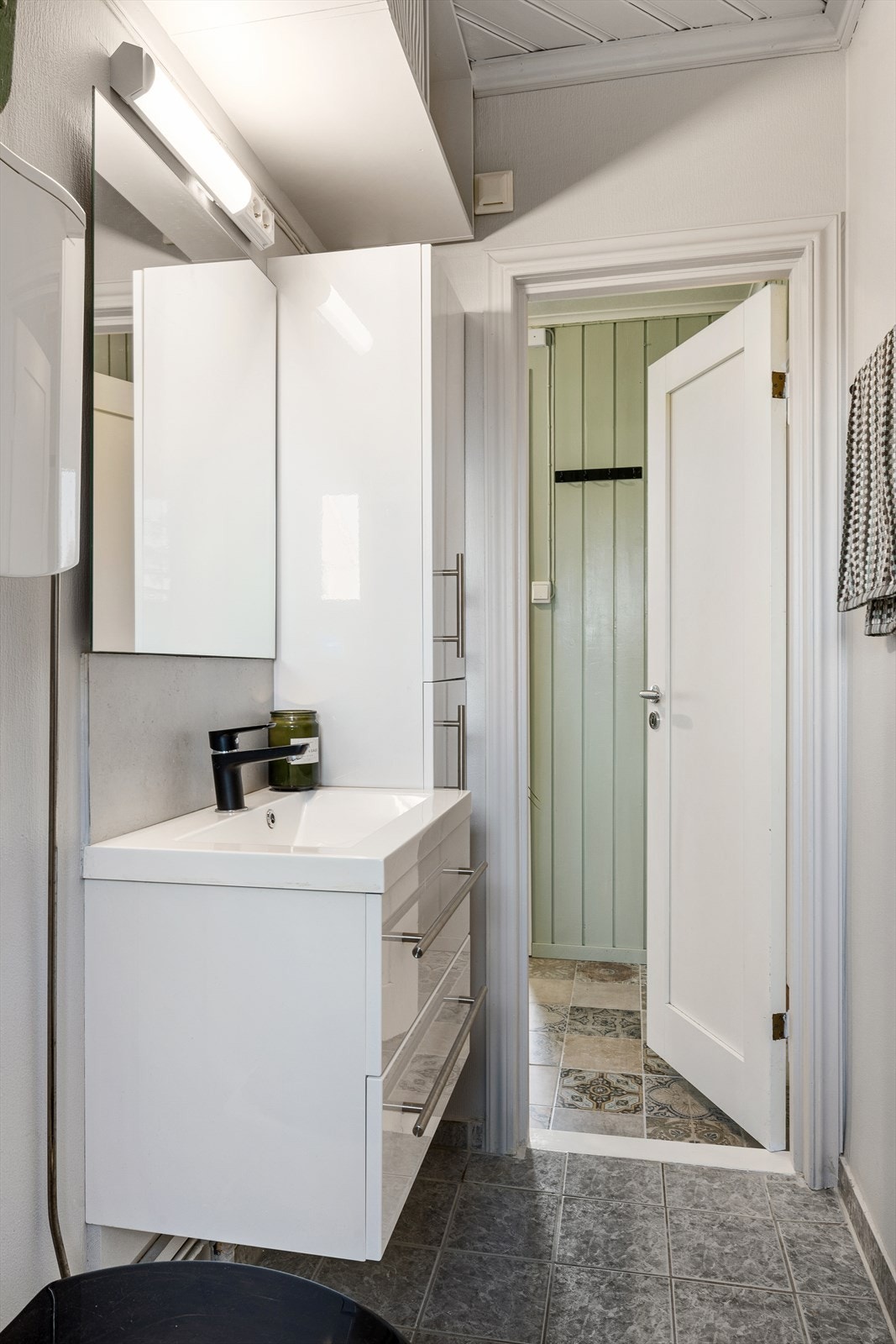 Flislagt bad sett mot døren til rommet Galleribilde