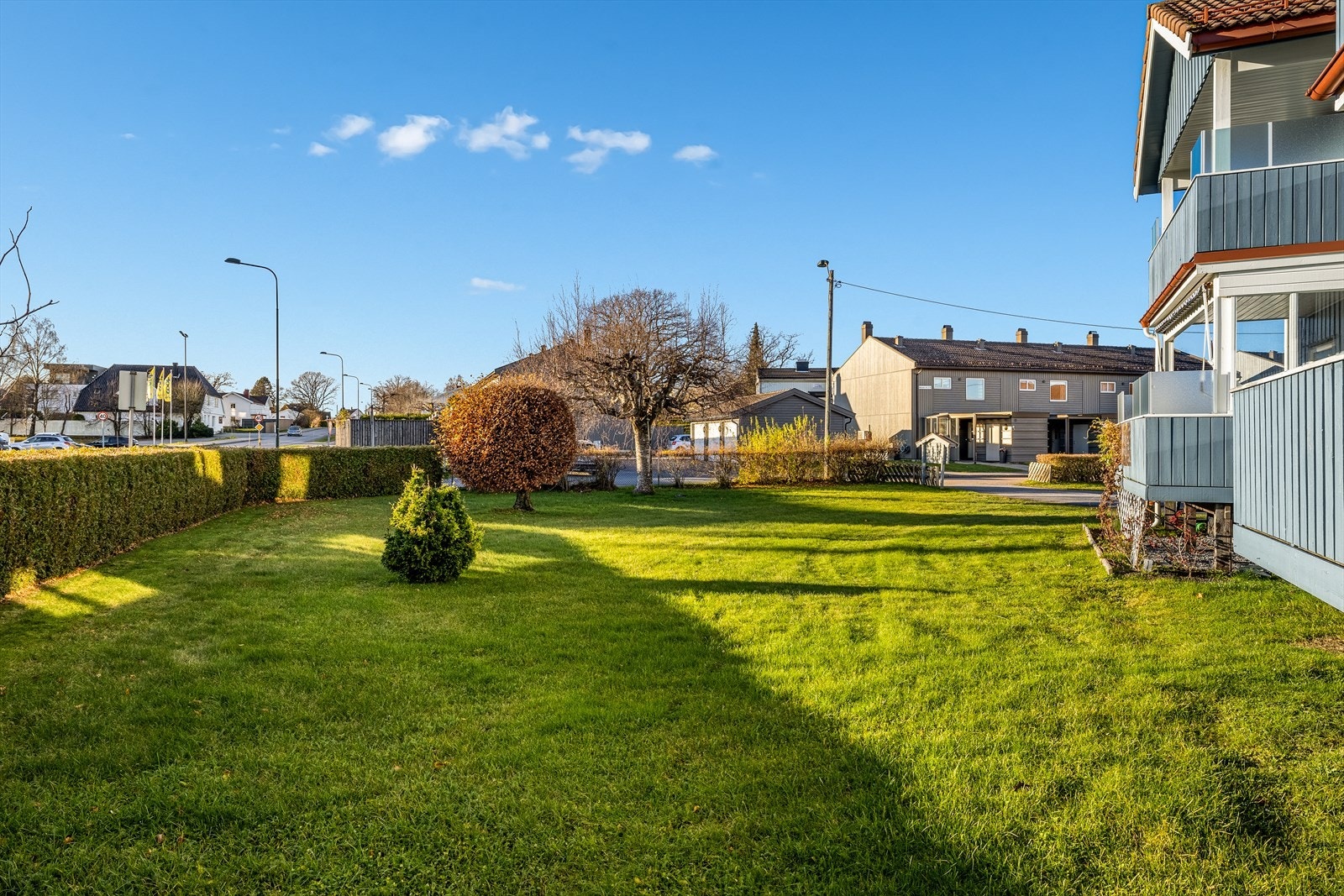 Stor felles hage med plen rundt hele huset og asfaltert gårdsplass Galleribilde