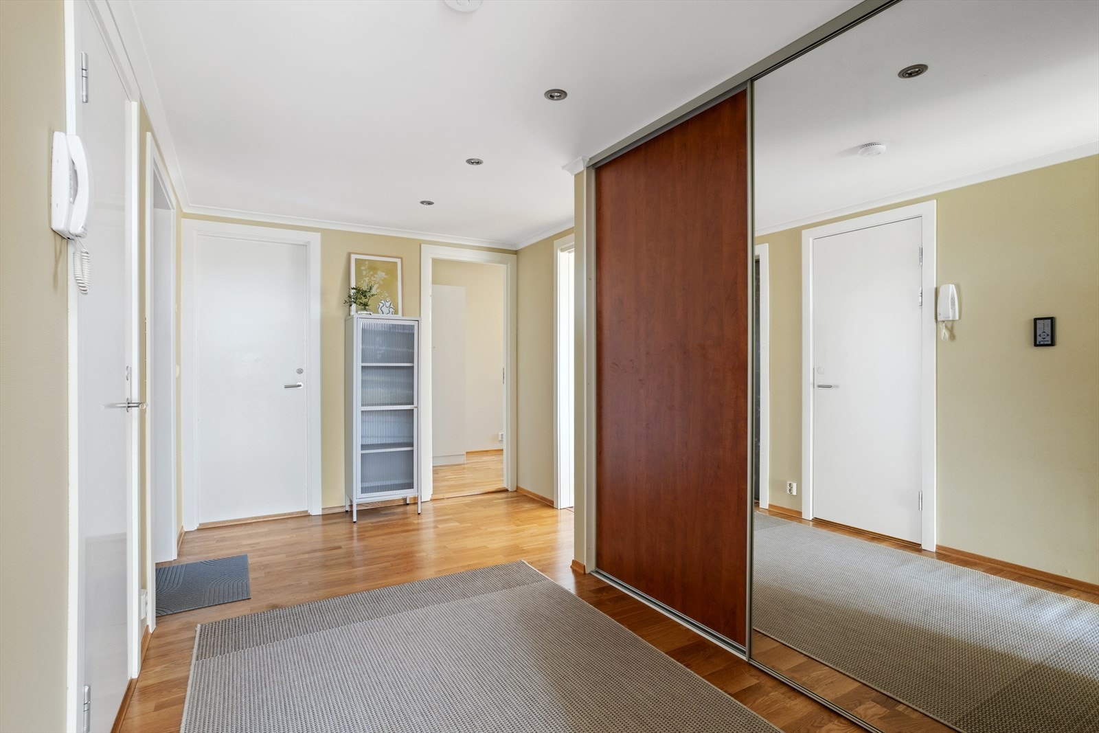 Leiligheten har en romslig gang med god plass til oppbevaring av yttertøy. Her finnes også en praktisk skyvedørsgarderobe. Galleribilde