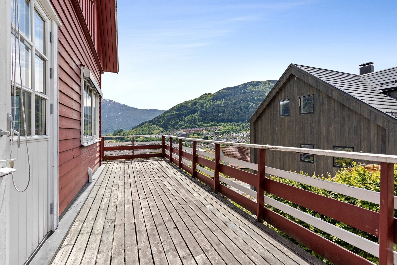 Frå kjøkkenet er det utgang til terrasse som strekker seg rundt hushjørnet langs framsida av huset. Galleribilde