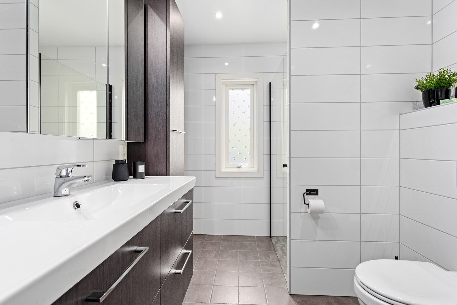 Badet er utstyrt med flott baderomsinnreiing, dusjhjørne, vegghengt toalett og opplegg til vaskemaskin og tørketrommel. Galleribilde