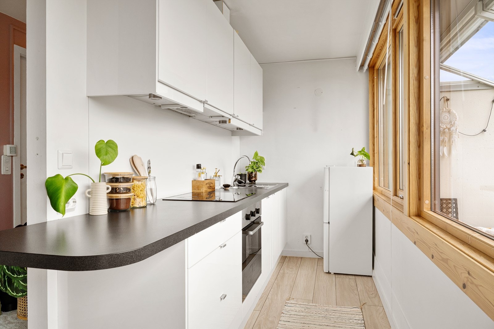 Kjøkkenet med hvite slette fronter og benkeplate av laminat. Galleribilde