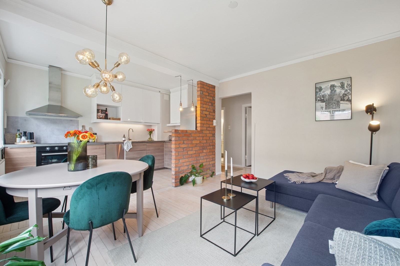 Planløsningen gir en åpen stue- og kjøkkenløsning med spisebord sentralt plassert, som skaper en naturlig overgang mellom sonene. Galleribilde