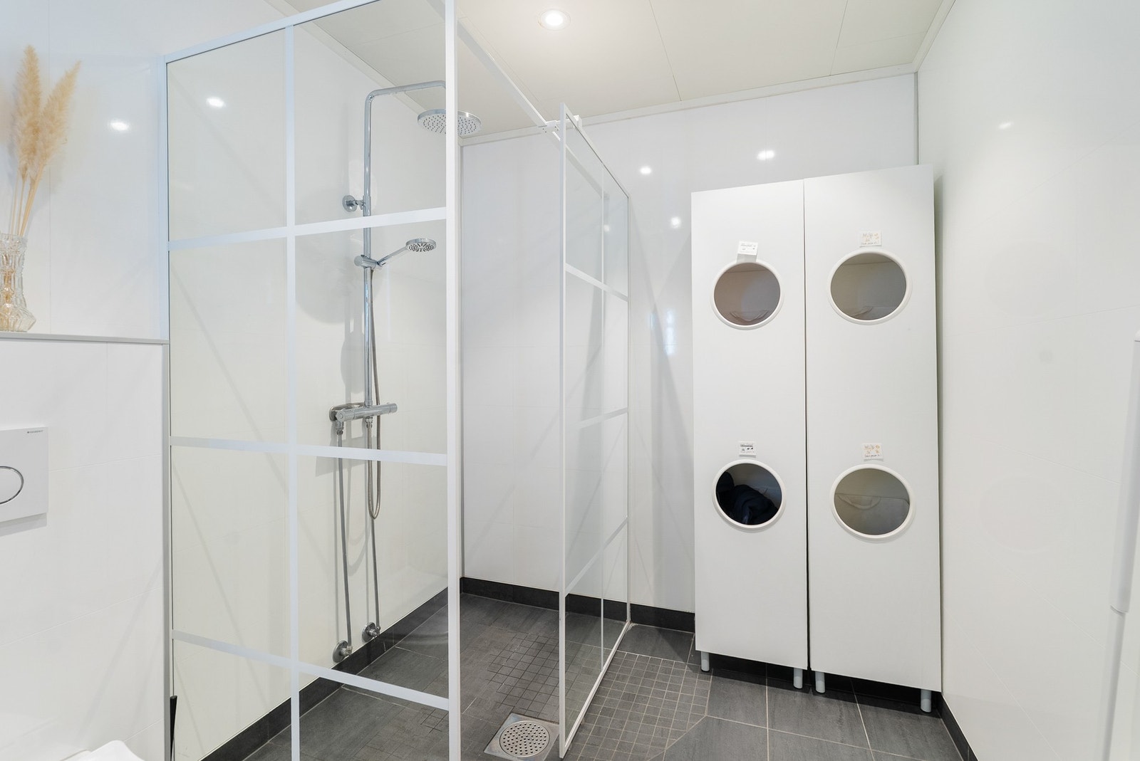 Badet har innredning med nedfelt servant, veggmontert toalett og dusjvegger/hjørne. Galleribilde