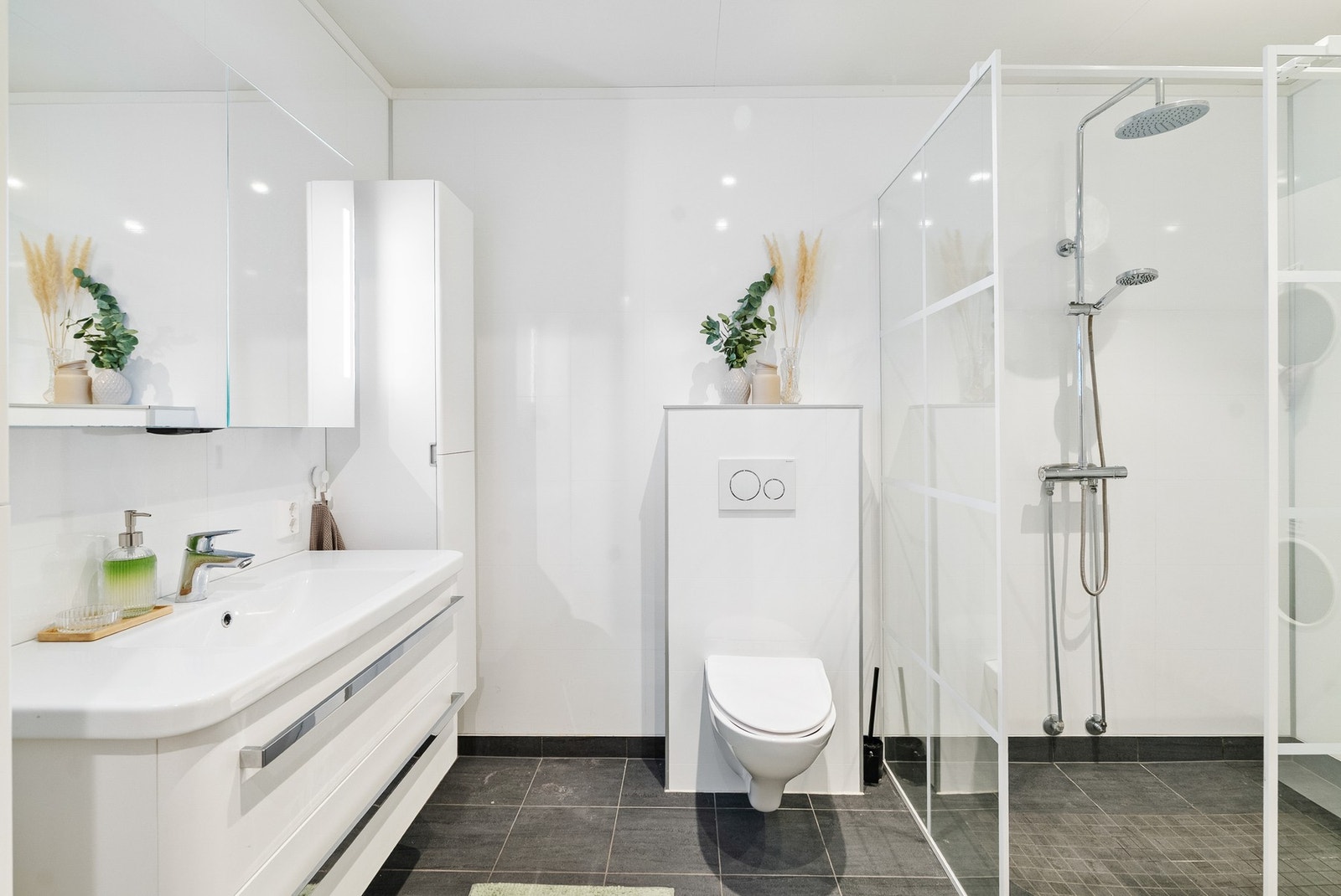 Bad med baderomsplater på vegg og flislagt gulv med varmekabler. Galleribilde