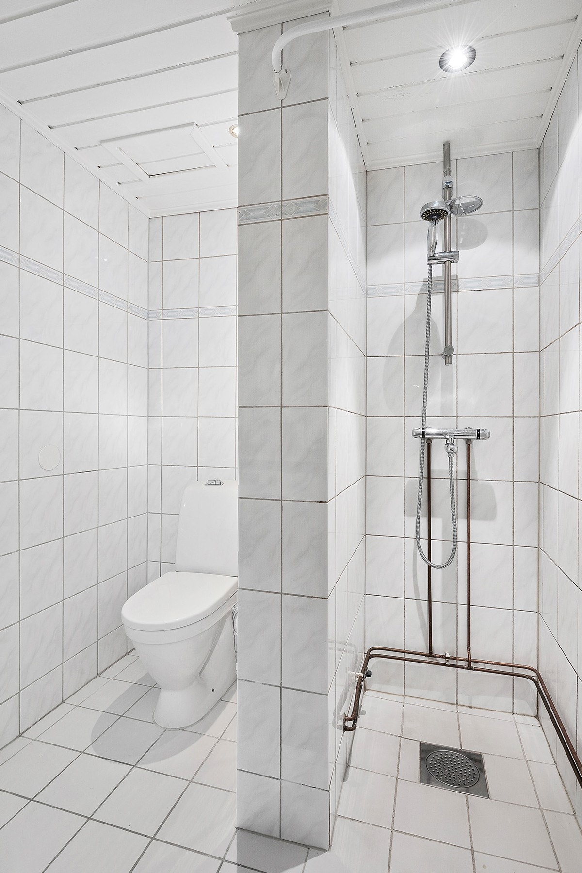 Romslig flislagt bad med gulvvarme og downlights pusset opp i regi av borettslaget Galleribilde