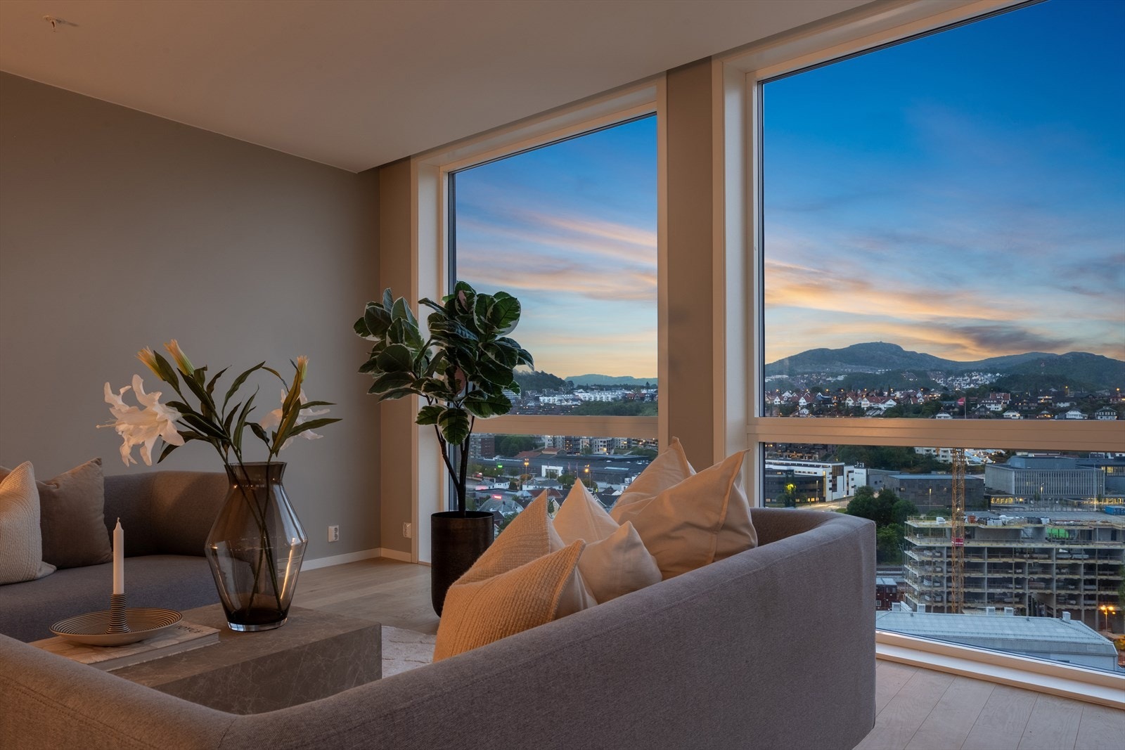 De store vinduene fra gulv til tak slipper inn rikelig med naturlig lys og skaper en magisk atmosfære om kvelden når byens lys skinner. Galleribilde