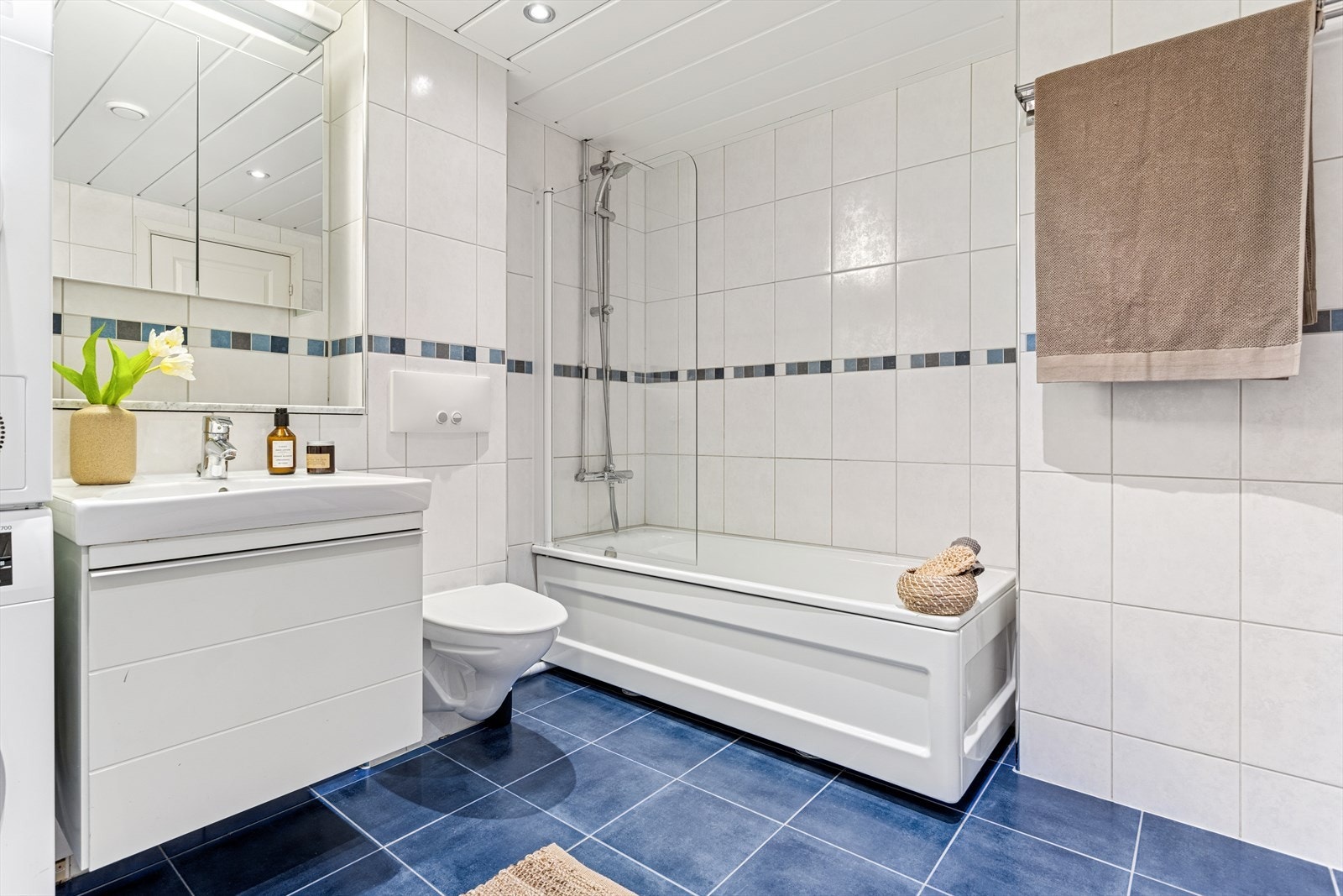 Pent flislagt bad med varmekabler i gulv og opplegg for vaskemaskin. Galleribilde