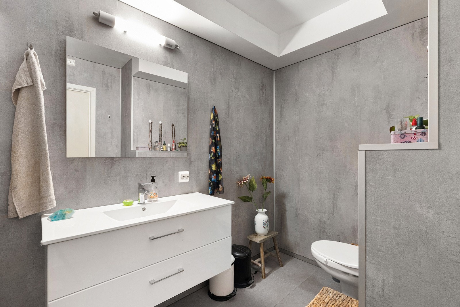 Badet er innredet med seksjon med hel servant, vegghengt toalett og dusj med glassvegger. Det er varme i gulvet og opplegg for vaskemaskin og tørketrommel. Galleribilde