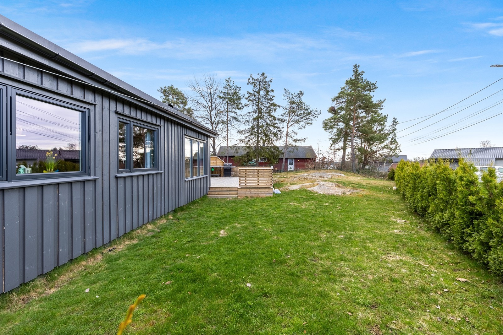 Tomten er opparbeidet med terrasser, plen og naturtomt Galleribilde