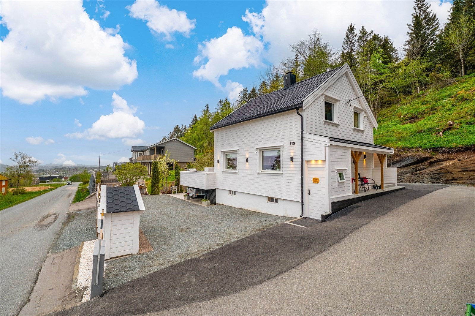 Eiendommen er pent opparbeidet med asfaltert og gruslagt biloppstillingsplass på begge sider av boligen. Galleribilde