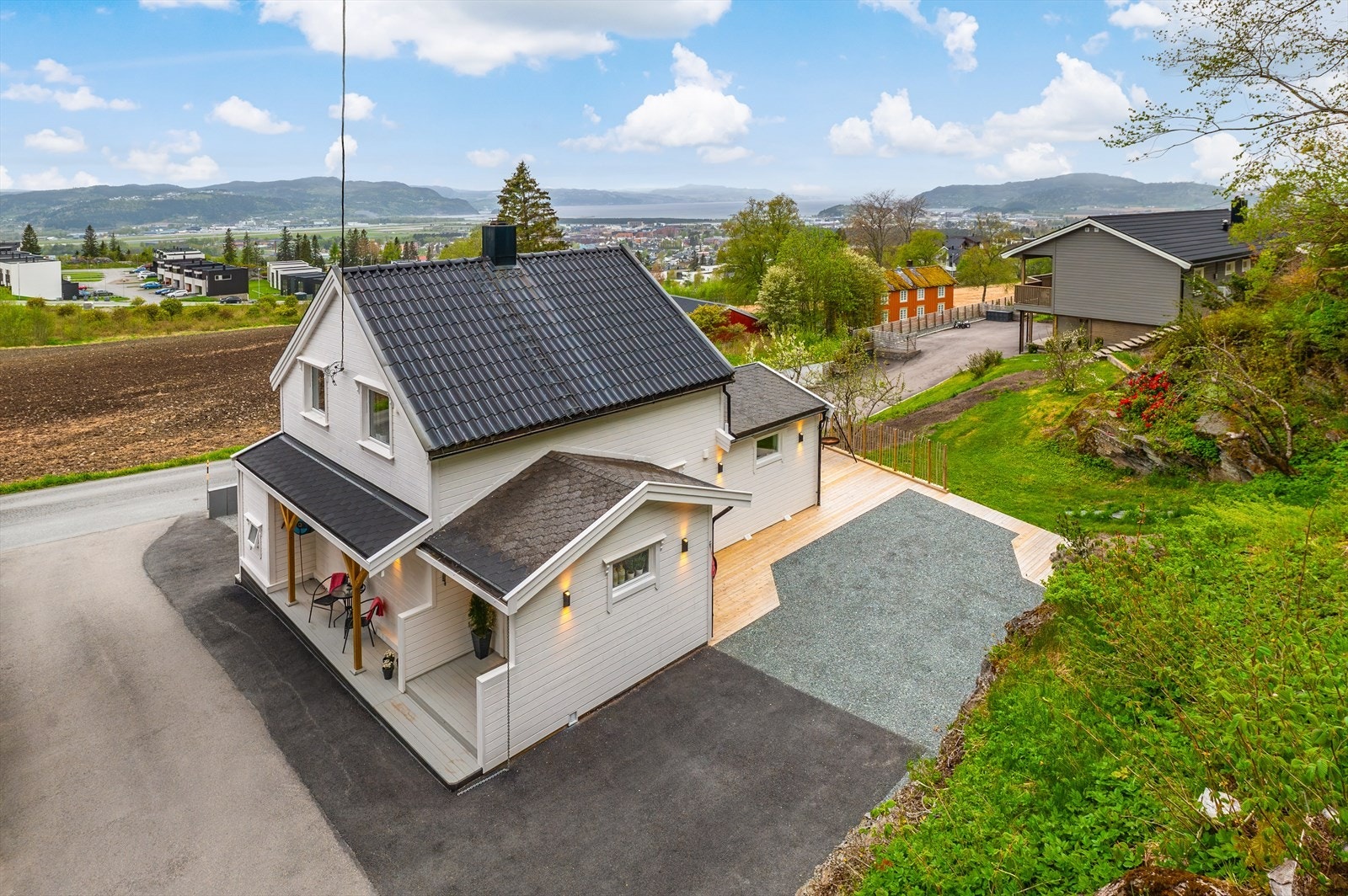 Eiendommen er pent opparbeidet med asfaltert og gruslagt biloppstillingsplass på begge sider av boligen. Galleribilde