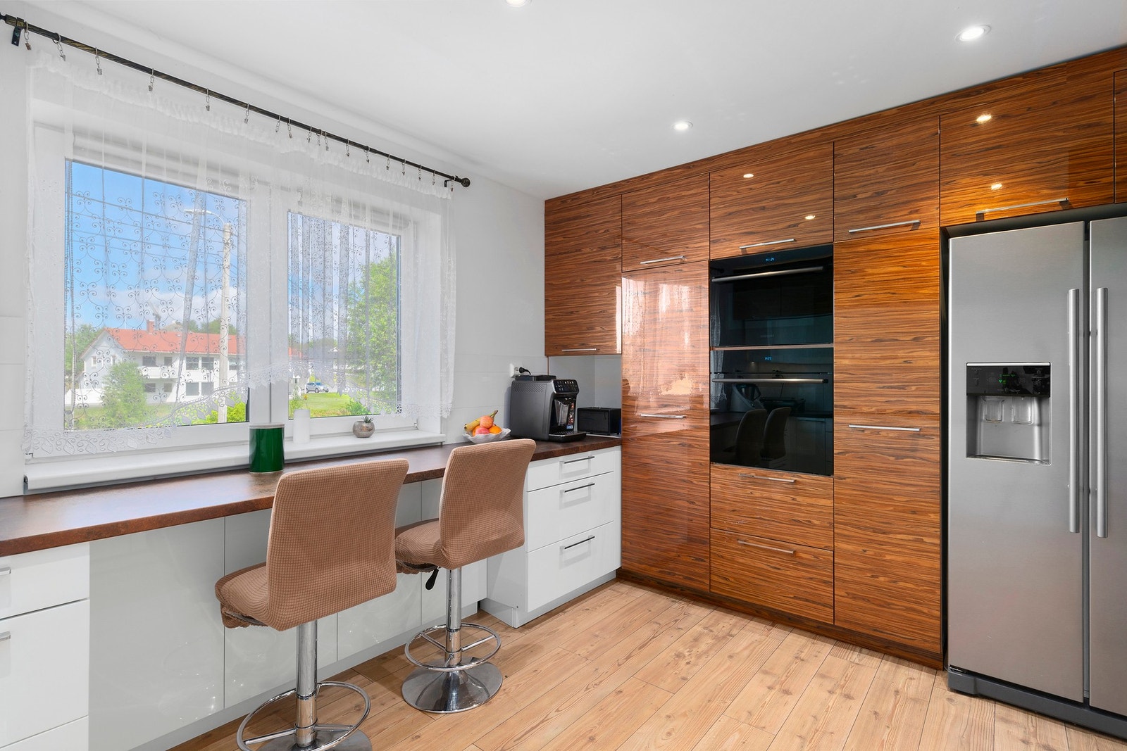 Kjøkkenet har en smart U-form som både gir effektiv arbeidsflyt og en hyggelig baravdeling til raske måltider eller sosial sone. Galleribilde